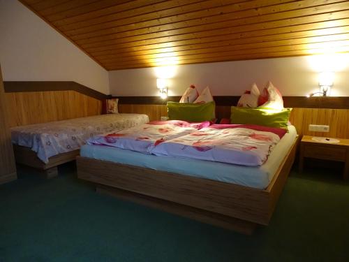 1 Schlafzimmer mit 2 Betten und grünen Kissen in der Unterkunft Ferienwohnung Hierzegger in Tauplitz