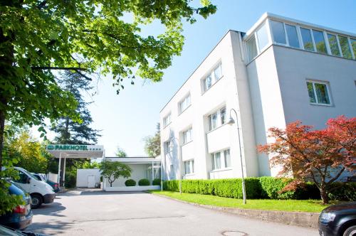 a white building with a parking lot in front of it at Parkhotel Styria in Steyr