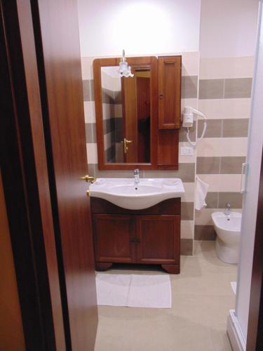 bagno con lavandino, specchio e servizi igienici di Hotel Europa a Rieti