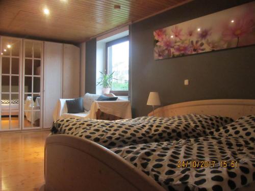 ein Schlafzimmer mit einem Bett mit einer Leopardenmuster-Decke in der Unterkunft Ferienwohnung am Fuß des Bayerischen Waldes in Wörth an der Donau