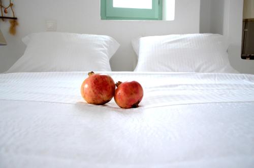 
a white and orange striped bed with an apple on it at Kontseta in Mérikhas
