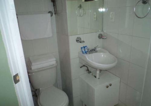 a white bathroom with a toilet and a sink at Satya Suites & Portal San Angel Flats in Mexico City