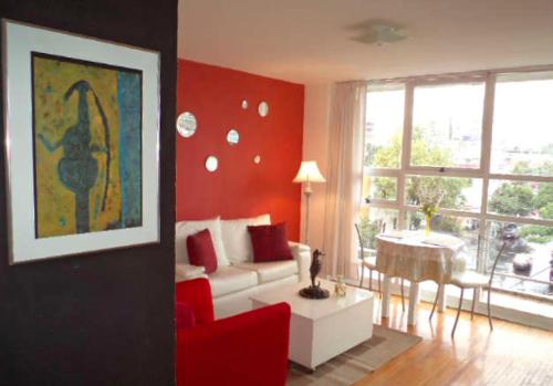 uma sala de estar com um sofá branco e uma mesa em Satya Suites & Portal San Angel Flats em Cidade do México