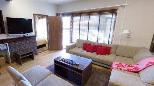 a living room with a couch and a tv at Holiday Club Tahko Spa Apartments in Tahkovuori