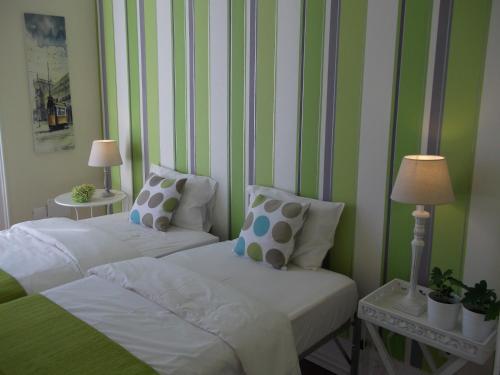 リスボンにあるAngola Top Floor 6 Bedroomsの緑と白のストライプを用いた客室内のベッド2台