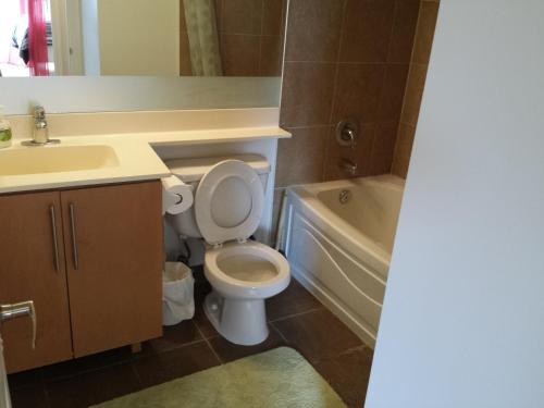 a bathroom with a toilet and a sink and a tub at 2 Bedroom 1 Bathroom Prime Location in Mississauga in Mississauga
