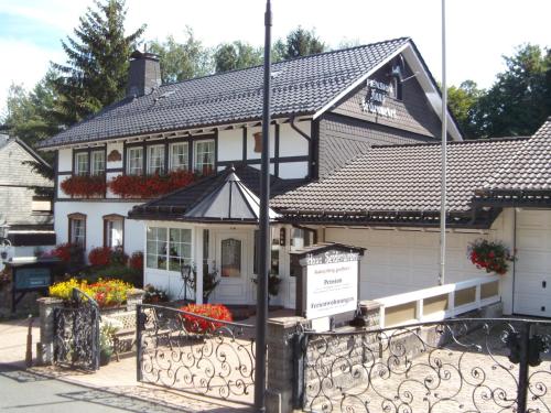 a house with a sign in front of it at Pension Haus Seidenweber in Schmallenberg