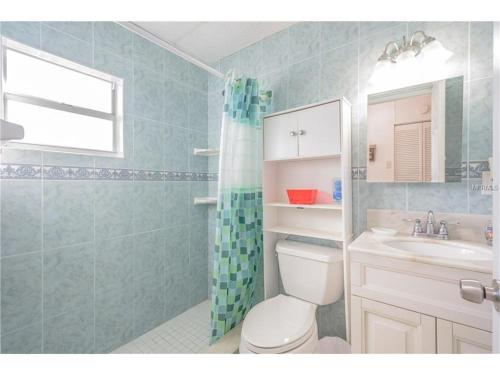 a bathroom with a toilet and a sink and a shower at Belleview Gulf Condos in Clearwater Beach