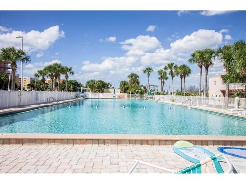 a large swimming pool with chairs and palm trees at Belleview Gulf Condos in Clearwater Beach