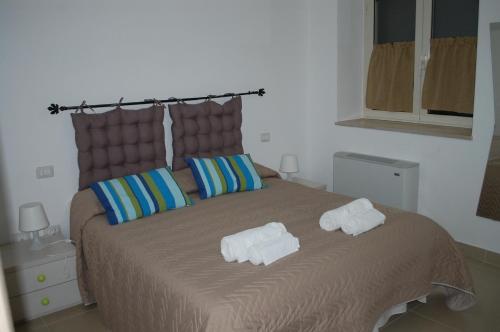 una camera da letto con un grande letto con asciugamani di All'ombra del Carrubo - Metaponto a Metaponto