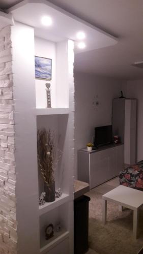 a living room with white walls and a couch and a table at Studio Apartman Marija in Zagreb