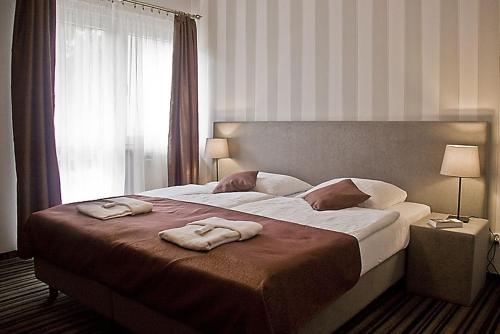 una camera da letto con un grande letto con due asciugamani di Dom Wypoczynkowy Słoneczna a Ustka