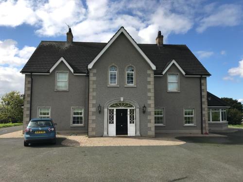 a house with a car parked in front of it at Kilcreeny Lodge in Lisburn