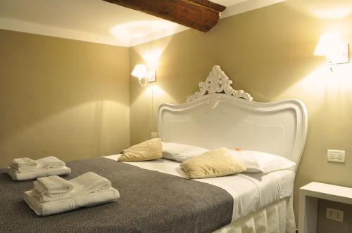 Un dormitorio con una cama blanca con toallas. en Hotel Nuovo Nord en Génova