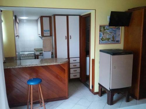 eine Küche mit einer Theke und einem Kühlschrank in der Unterkunft Flat para ate 4 pessoas - Frente a Praia dos Anjos in Arraial do Cabo