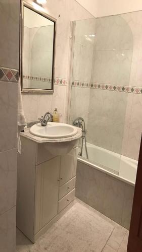 a bathroom with a sink and a tub and a mirror at Lisa House in Sintra