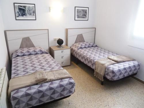una camera con due letti e un comodino di Apartament Nou Fontalba a Ribes de Freser