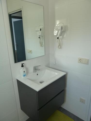 a white bathroom with a sink and a mirror at Apartament Nou Fontalba in Ribes de Freser