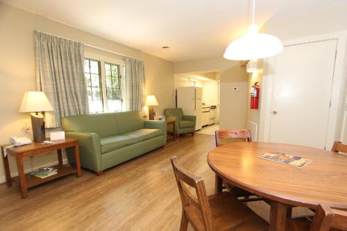 a living room with a table and a green couch at Kentucky Dam Village State Resort Park in Gilbertsville