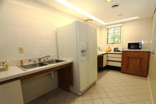 a kitchen with a white refrigerator and a sink at Kentucky Dam Village State Resort Park in Gilbertsville