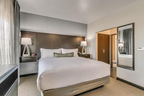 a bedroom with a large white bed and two lamps at Staybridge Suites Lubbock South by IHG in Lubbock