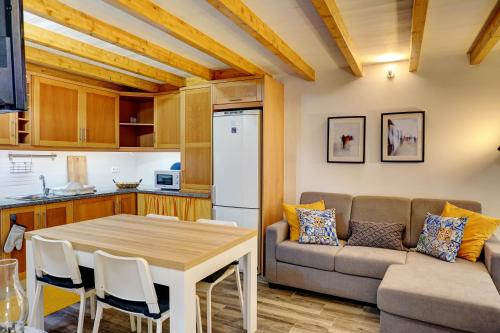a kitchen and living room with a table and a couch at PenicheArtHouse in Peniche