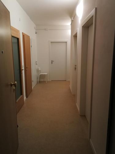 a corridor of an empty room with two doors at Central Rooms in Bolzano