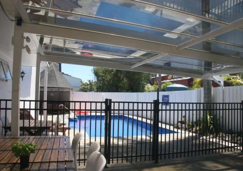 a patio with a fence and a swimming pool at Edelweiss Motel in Paihia