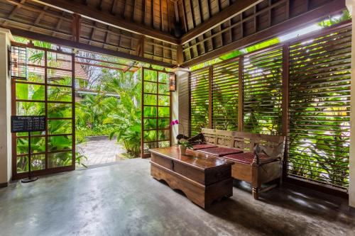a room with a bed in a room with windows at Kejora Suites in Sanur