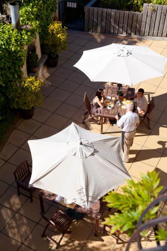 a group of people sitting at a table with umbrellas at Browns Boutique Hotel in Queenstown