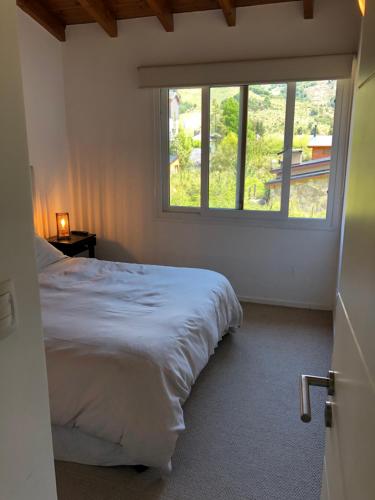 ein Schlafzimmer mit großem Bett und Fenster in der Unterkunft Complejo Mil50 in San Carlos de Bariloche