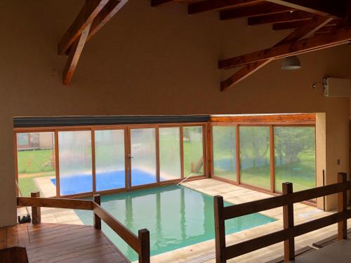 einen Innenpool mit großem Fenster in der Unterkunft Complejo Mil50 in San Carlos de Bariloche