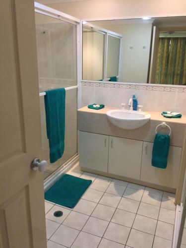 a bathroom with a sink and a shower at Cairns Golf Course Apartment in Cairns