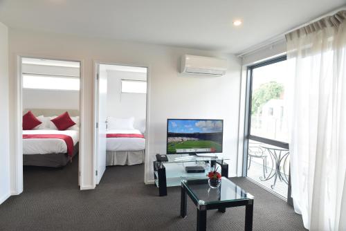 una habitación de hotel con cama y TV y una habitación en Bealey Plaza Motel en Christchurch