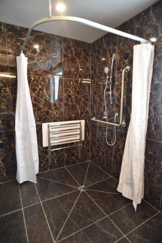 a bathroom with a shower with a bench in it at Bealey Plaza Motel in Christchurch