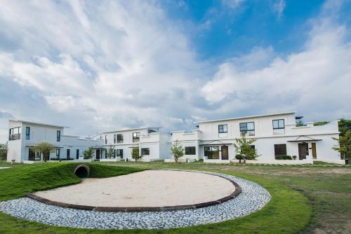a large white house with a circular driveway at Shangri Longluan Lake One B&B in Hengchun