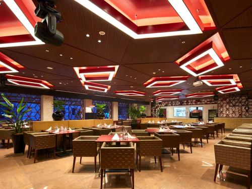 a dining room with tables and chairs and lights at Hotel Flags Kuju Kusima in Sasebo
