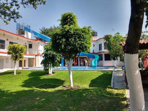 a park with a tree and a playground at Hotel Quinta Paraiso in Cocoyoc