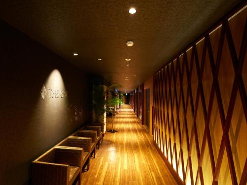 a long hallway with benches in a restaurant at Hotel Flags Kuju Kusima in Sasebo