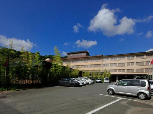 a parking lot with cars parked in front of a building at Hotel Flags Kuju Kusima in Sasebo