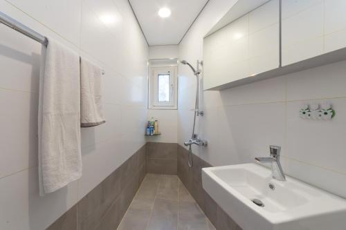 a white bathroom with a sink and a shower at Guesthouse The Kims in Seoul