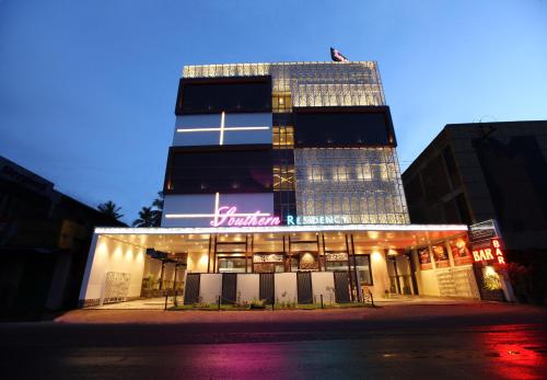 a building with a neon sign in front of it at Hotel Southern Residency- near to SIPCOT in Kelambākkam