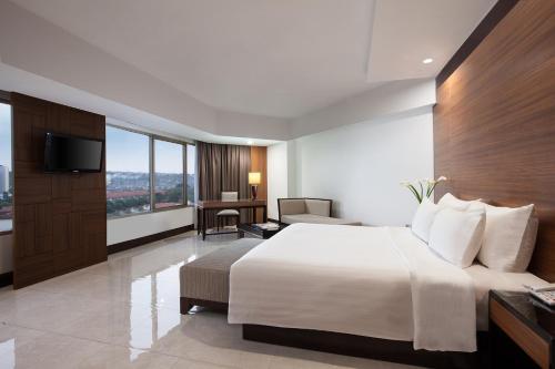 Tempat tidur dalam kamar di Hotel Santika Premiere Semarang