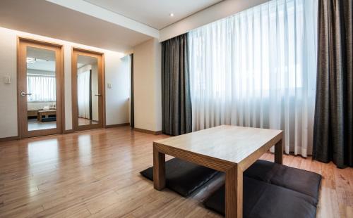 a living room with a wooden table and a window at Hotel Prince Seoul in Seoul