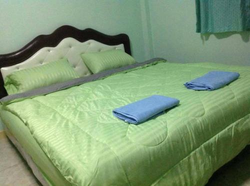 a green bed with two pillows on top of it at Daddy's homestay in Ban Bang Krasan