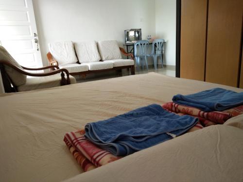 two towels are sitting on top of a bed at Harum Manis Country House in Kangar