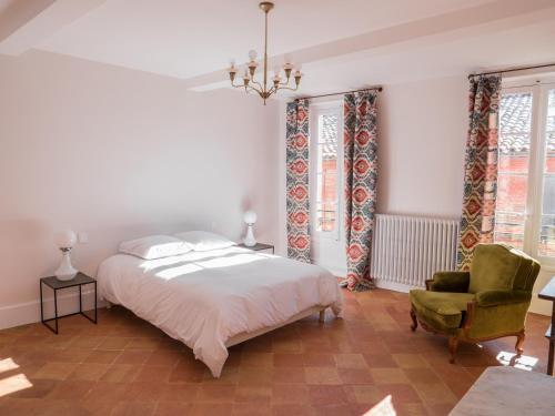 une chambre avec un lit, une chaise et des fenêtres dans l'établissement La Cour Verte, à Gaillac