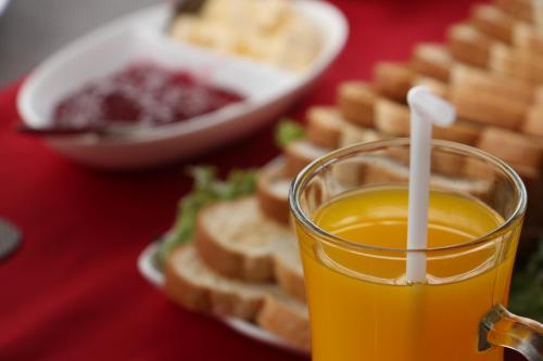 a glass of orange juice next to a plate of waffles at Misty Paradise of Lake Gregory in Nuwara Eliya