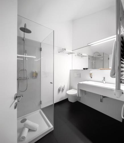 a white bathroom with a shower and a sink at Pedras Salgadas Spa & Nature Park in Pedras Salgadas