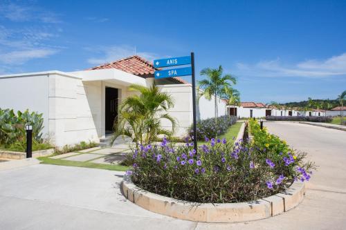 a street sign in front of a building with purple flowers at Pantai Indah Lagoi Bintan in Lagoi